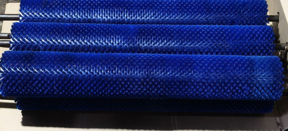 Blue nylon cylindrical roller brushes mounted on shafts